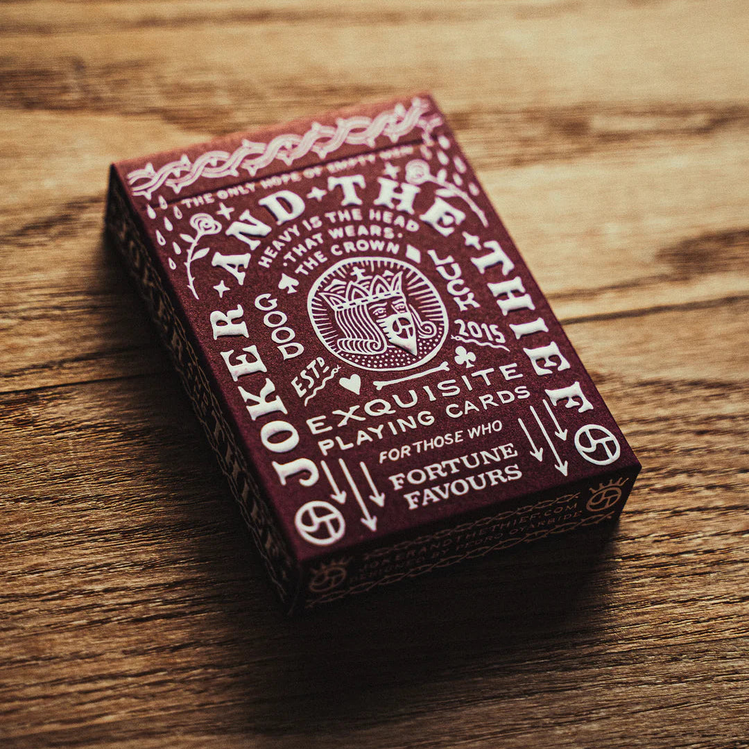 Crown: Royal Purple Edition Playing card box with intricate design on a wooden surface