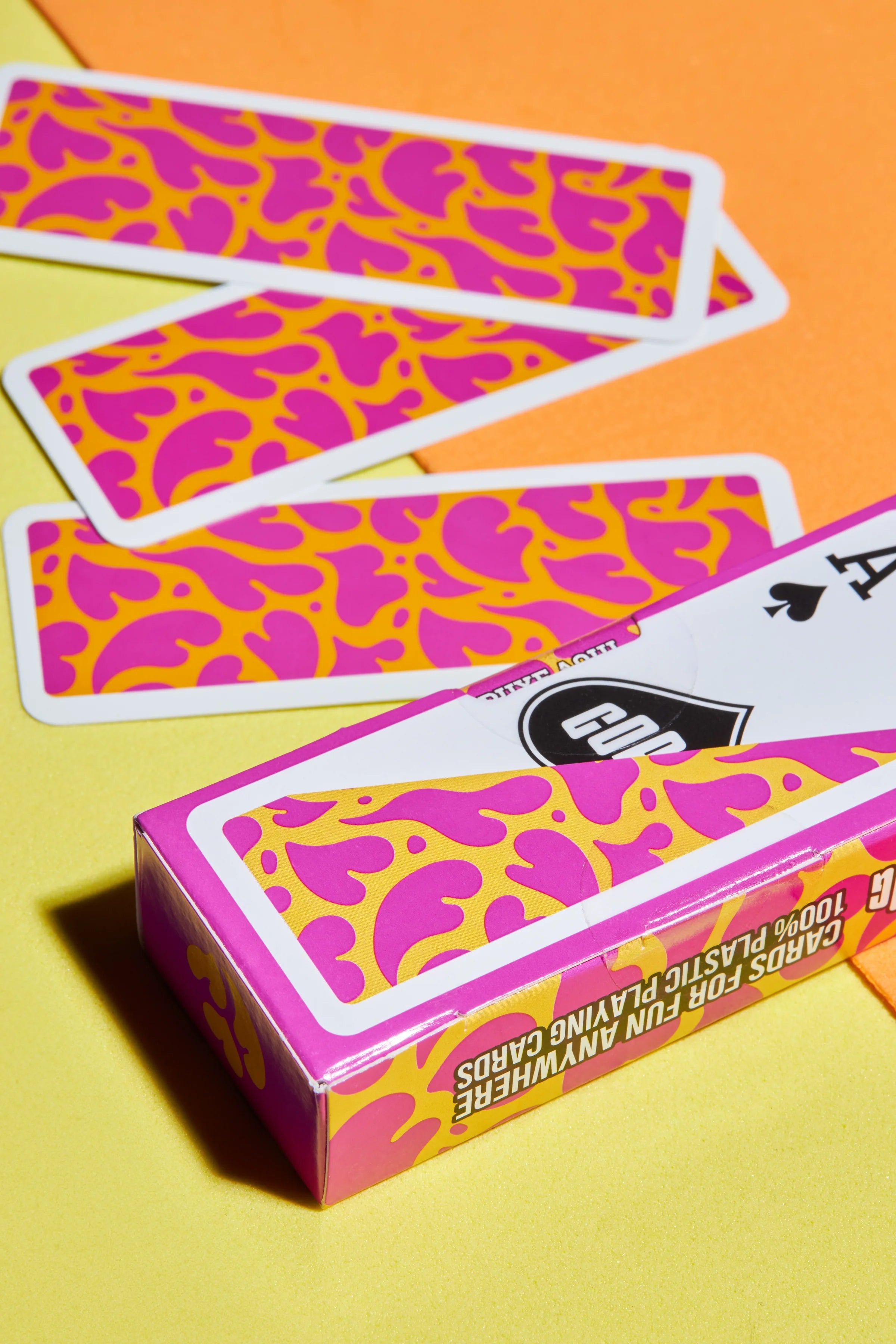 Copag Go Deck – Hearts Design Playing cards with pink and orange pattern on a yellow and orange background