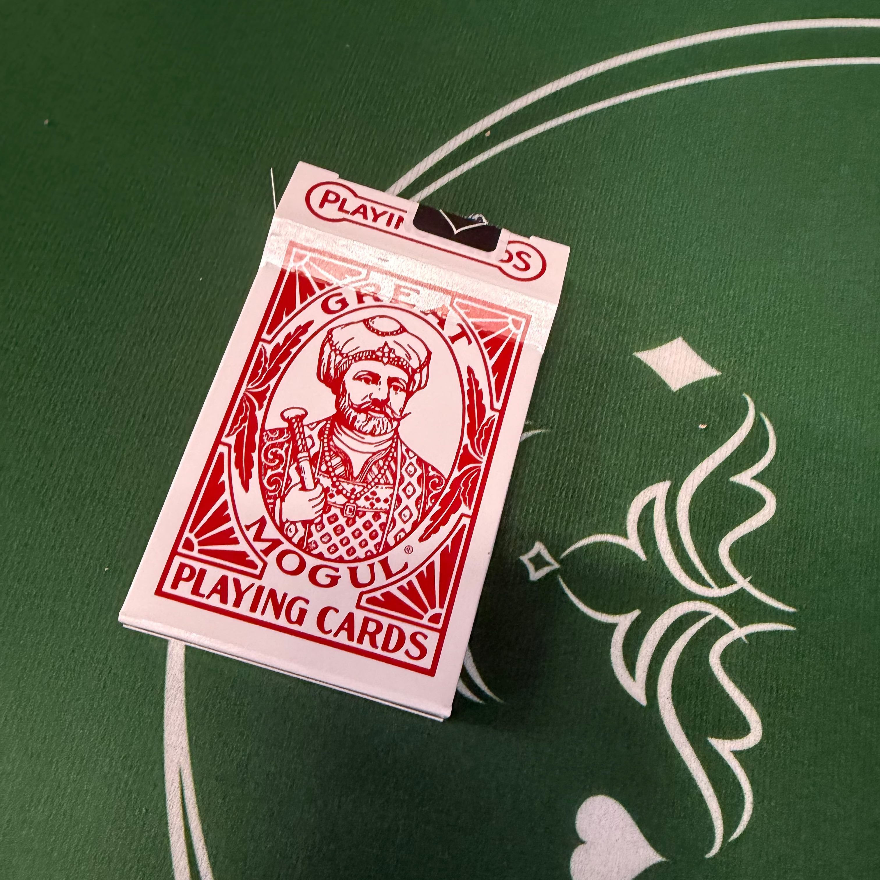 Great Mogul playing card box with a red label on a green surface