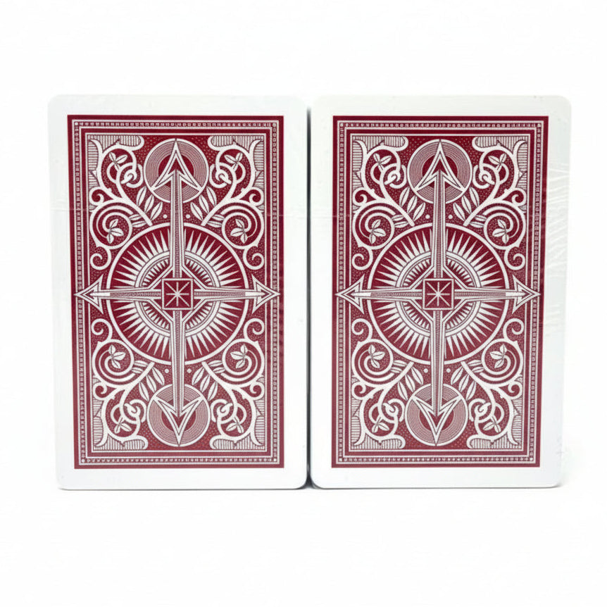 Two red KEM Canasta playing cards with white designs on a white background