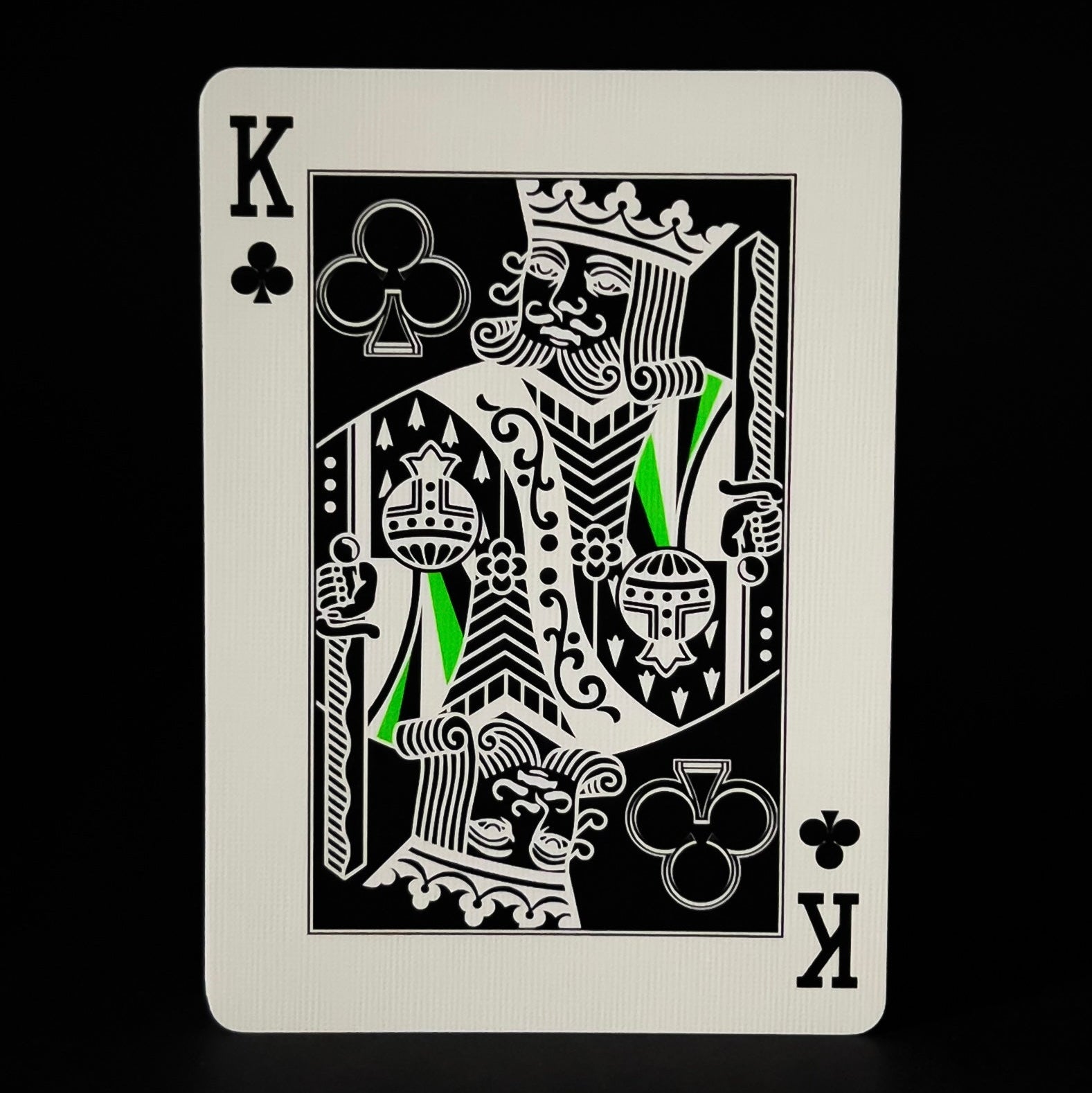 Descendents playing card with King of Clubs design on a black background