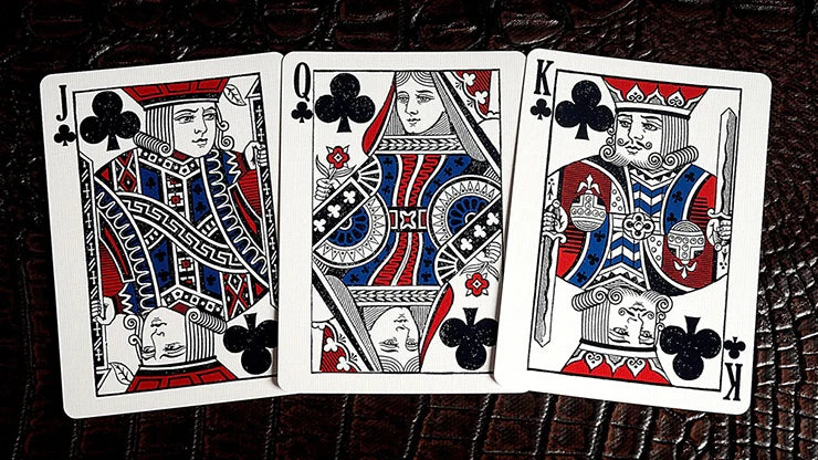 Three playing cards: Jack, Queen, and King of Clubs from a decorative deck on a dark surface.