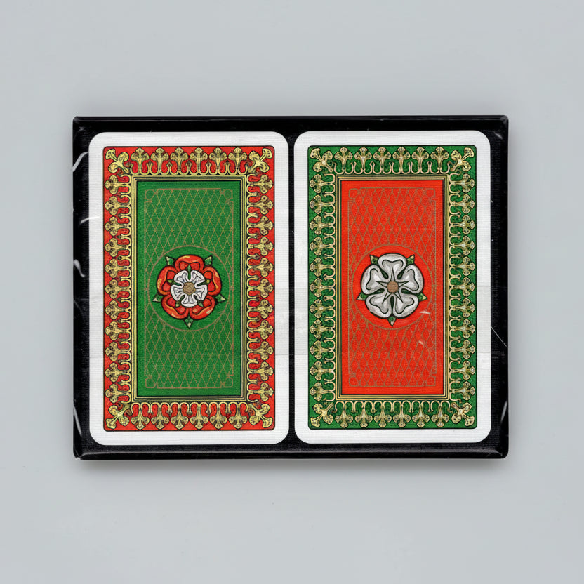 Back designs of Piatnik Tudor Rose playing cards showing green and red Tudor‑rose patterns with ornate borders.
