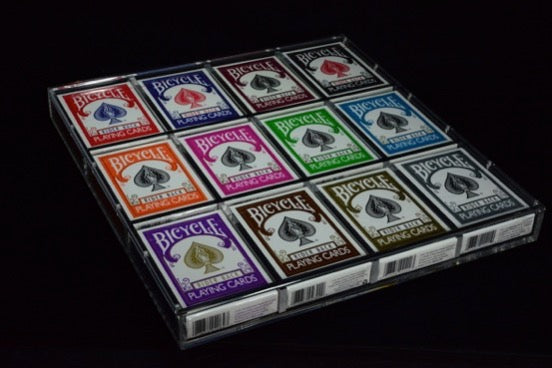 Twelve colored Bicycle decks displayed flat in a Carat X4x3 full-brick acrylic case
