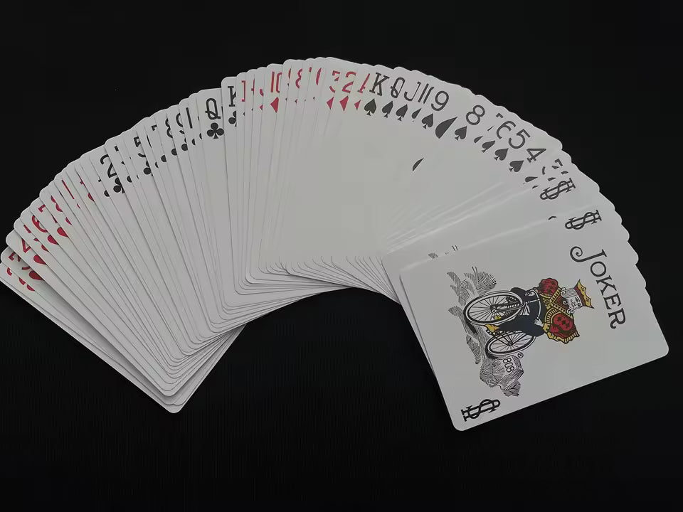 Fanned-out deck of playing cards with a joker card on a black background