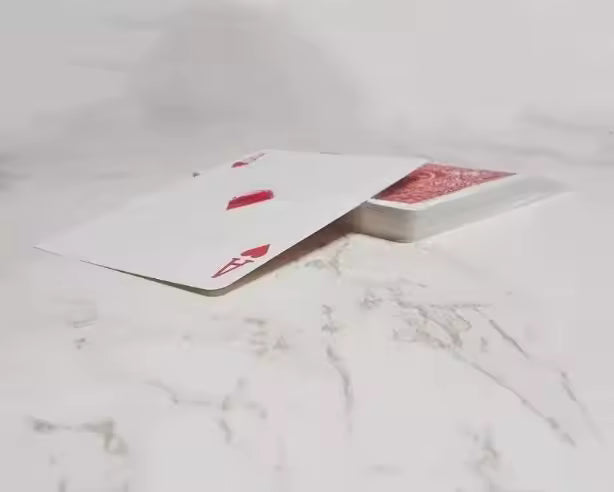 Open book with playing cards on a marble surface
