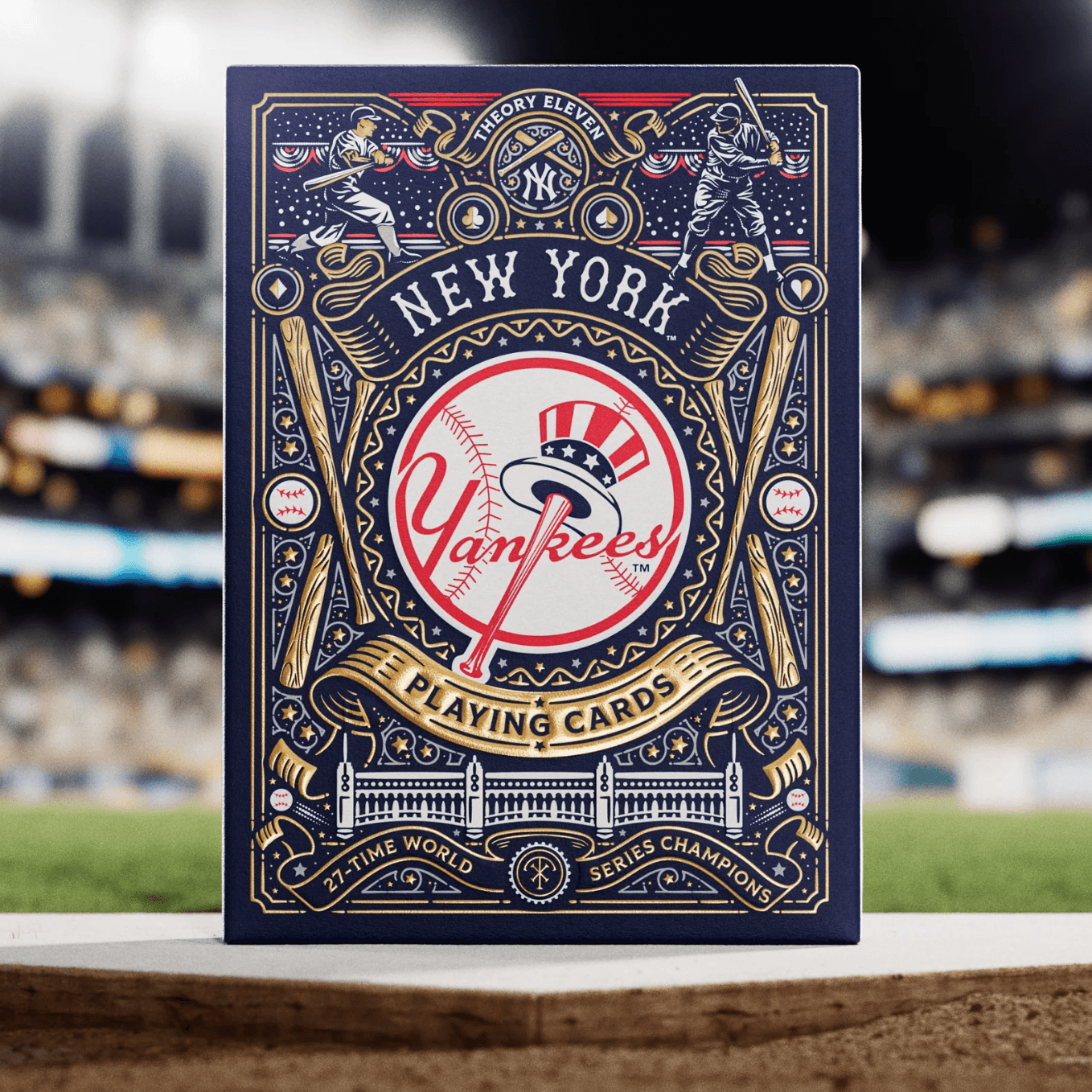 Close-up of Yankees Ace of Spades held in front of a blurred baseball stadium background.