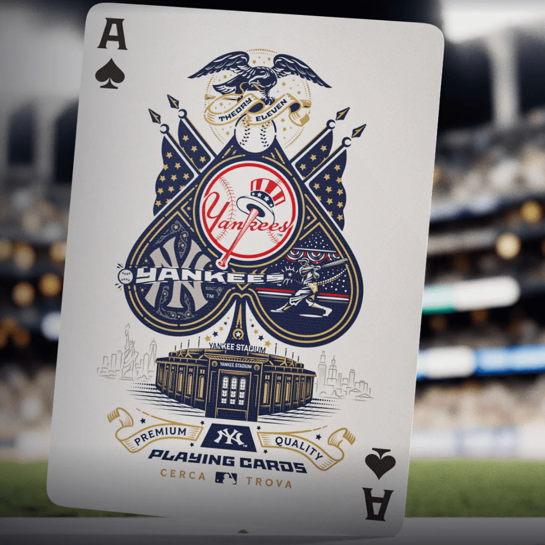 Close-up of Yankees Ace of Spades held in front of a blurred baseball stadium background.