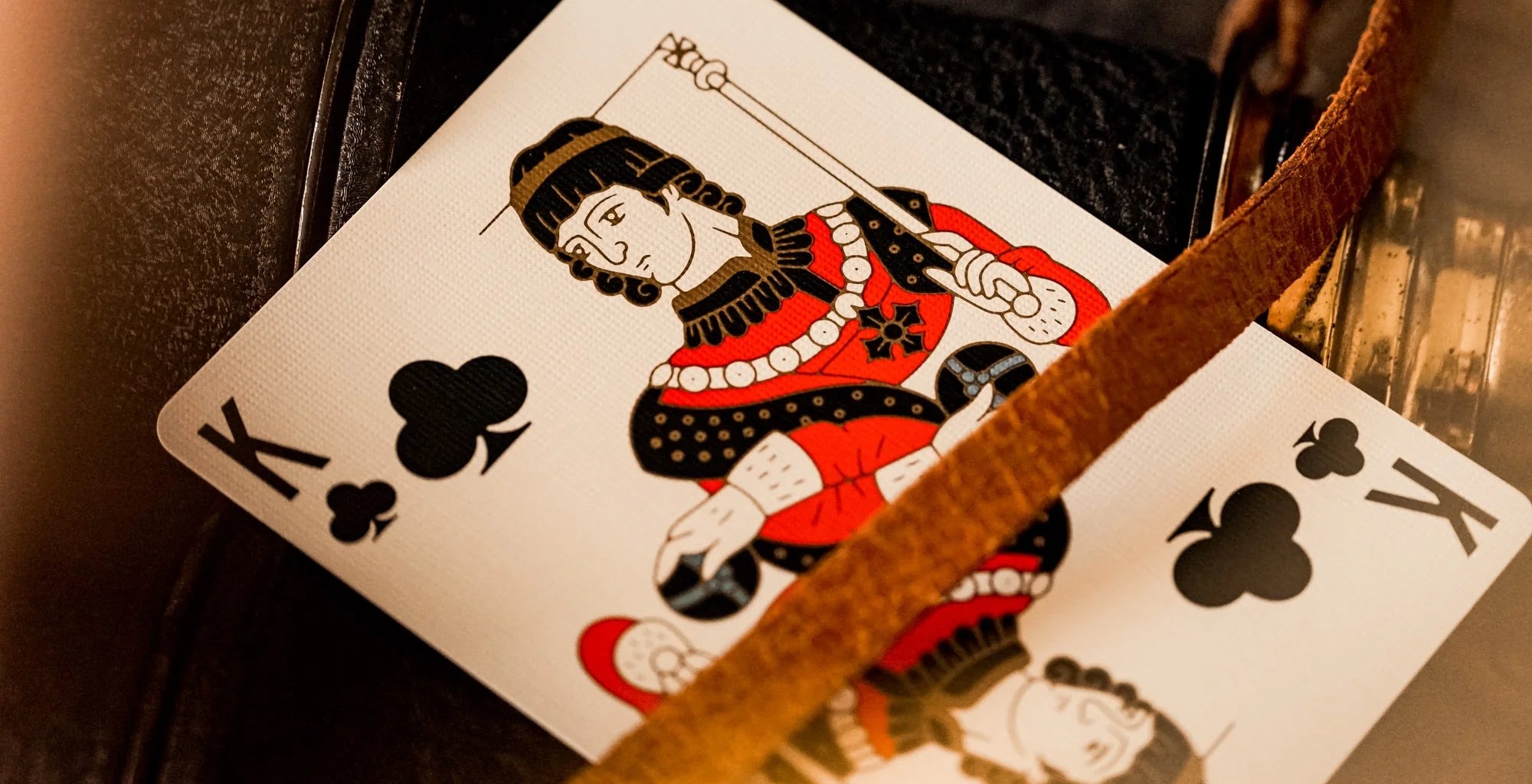 Playing card with a king of clubs design on a textured surface