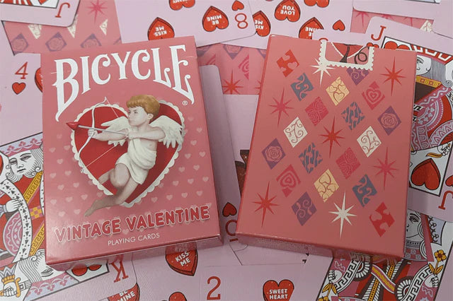 Two Bicycle Vintage Valentine playing card decks on a background of additional cards.