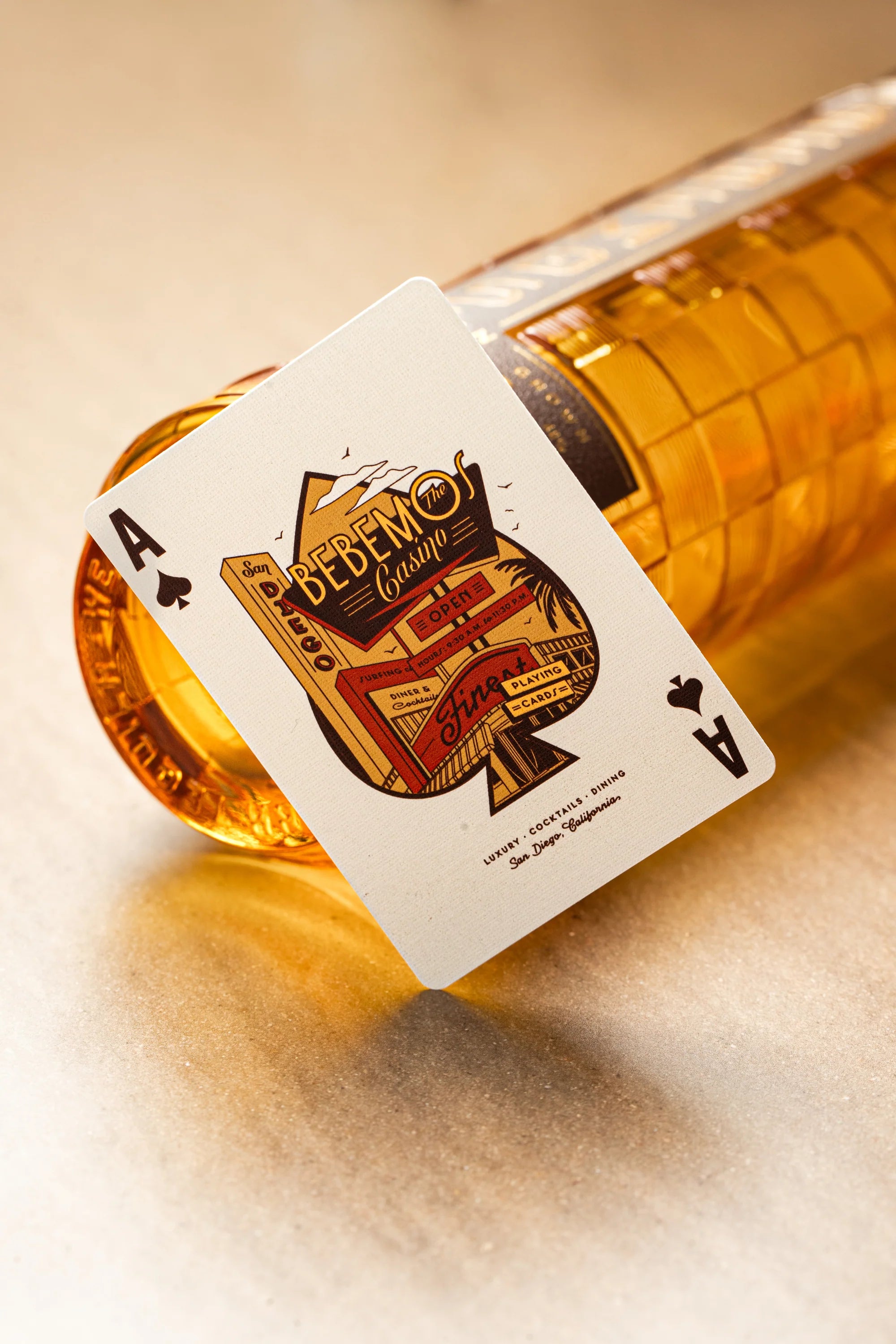 Playing card with a bottle of whiskey, featuring a Bebemos Casino logo.