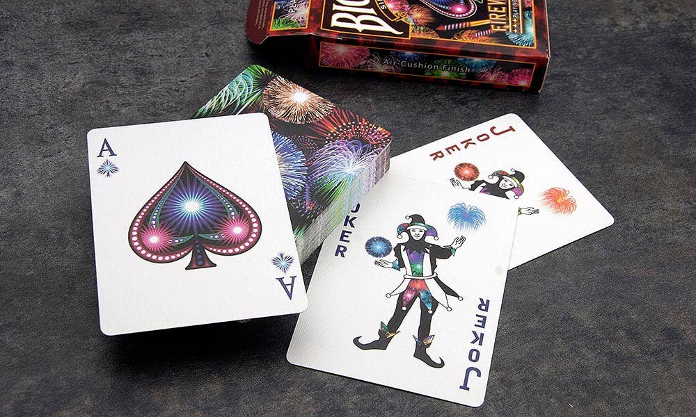 Playing cards with a joker card and a deck of cards on a dark surface