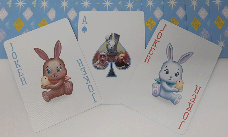Three playing cards featuring cartoon characters on a patterned background