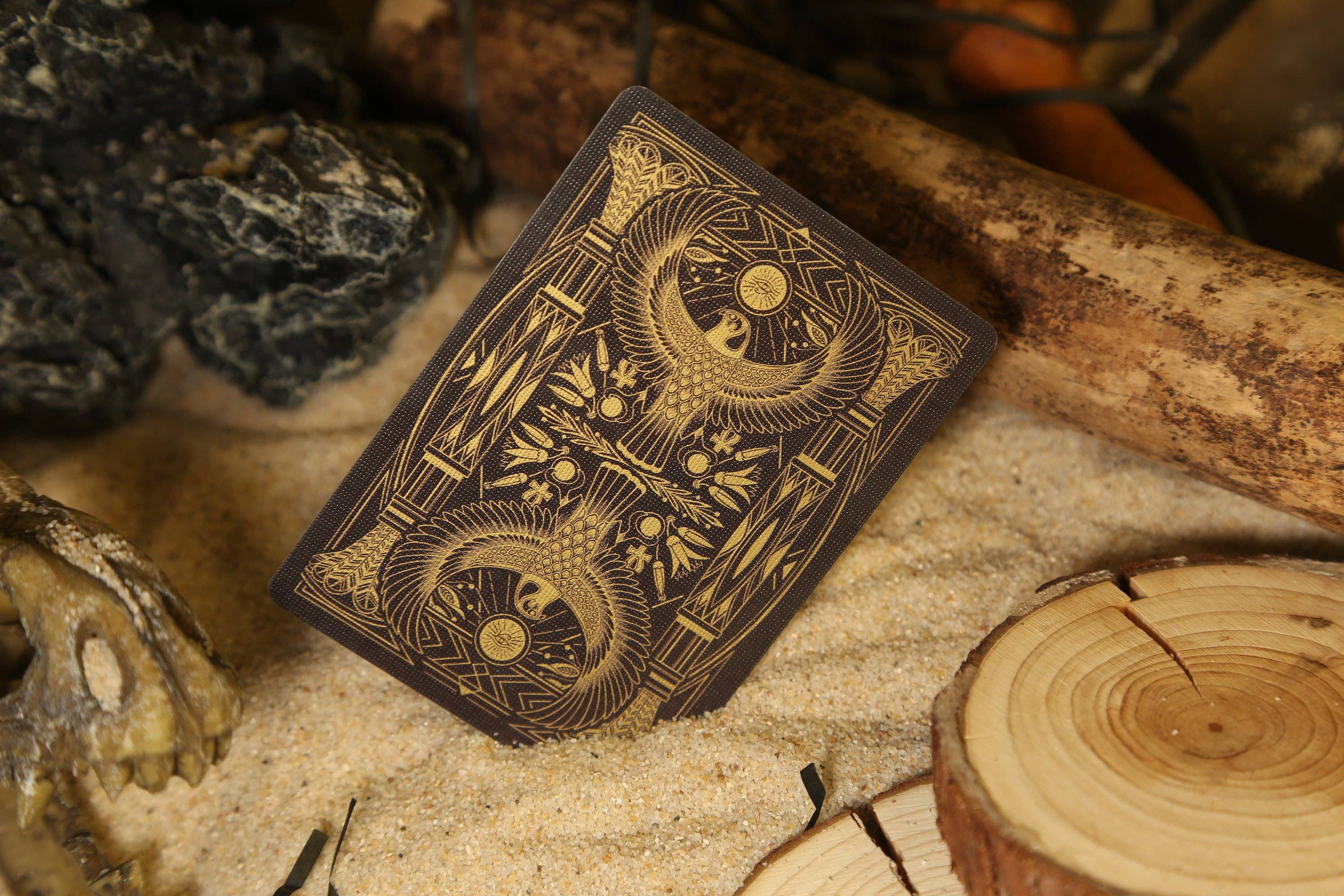 Decorative card with intricate designs on a rustic background with wood and stones.