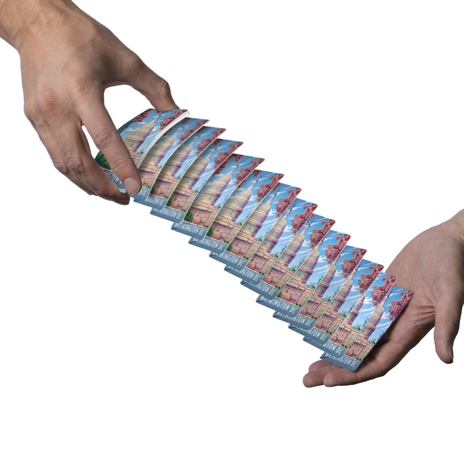 Washington D.C. Boardwalk playing cards cascading between two hands with Capitol card backs visible