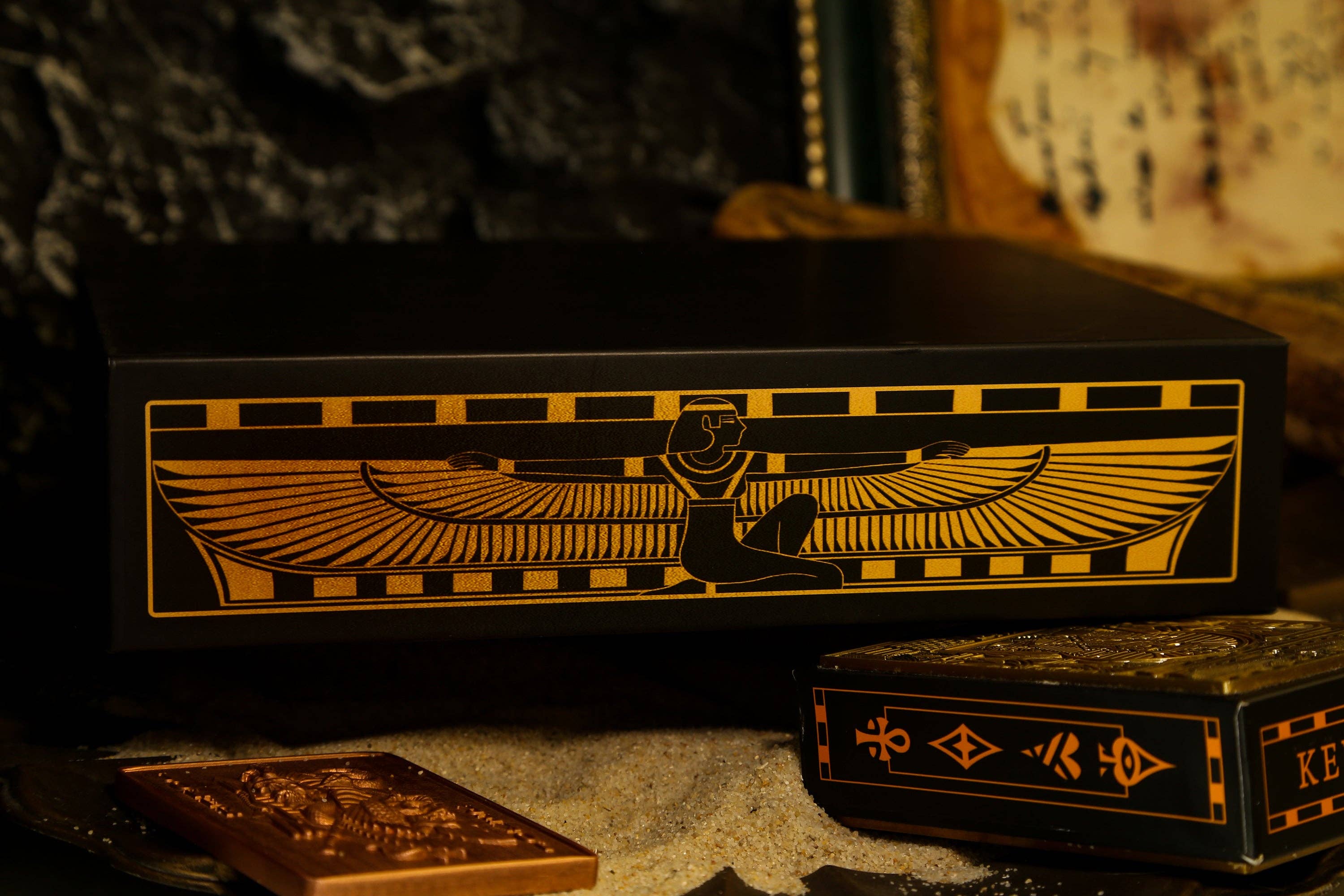 Decorative boxes with winged lion design on a dark background