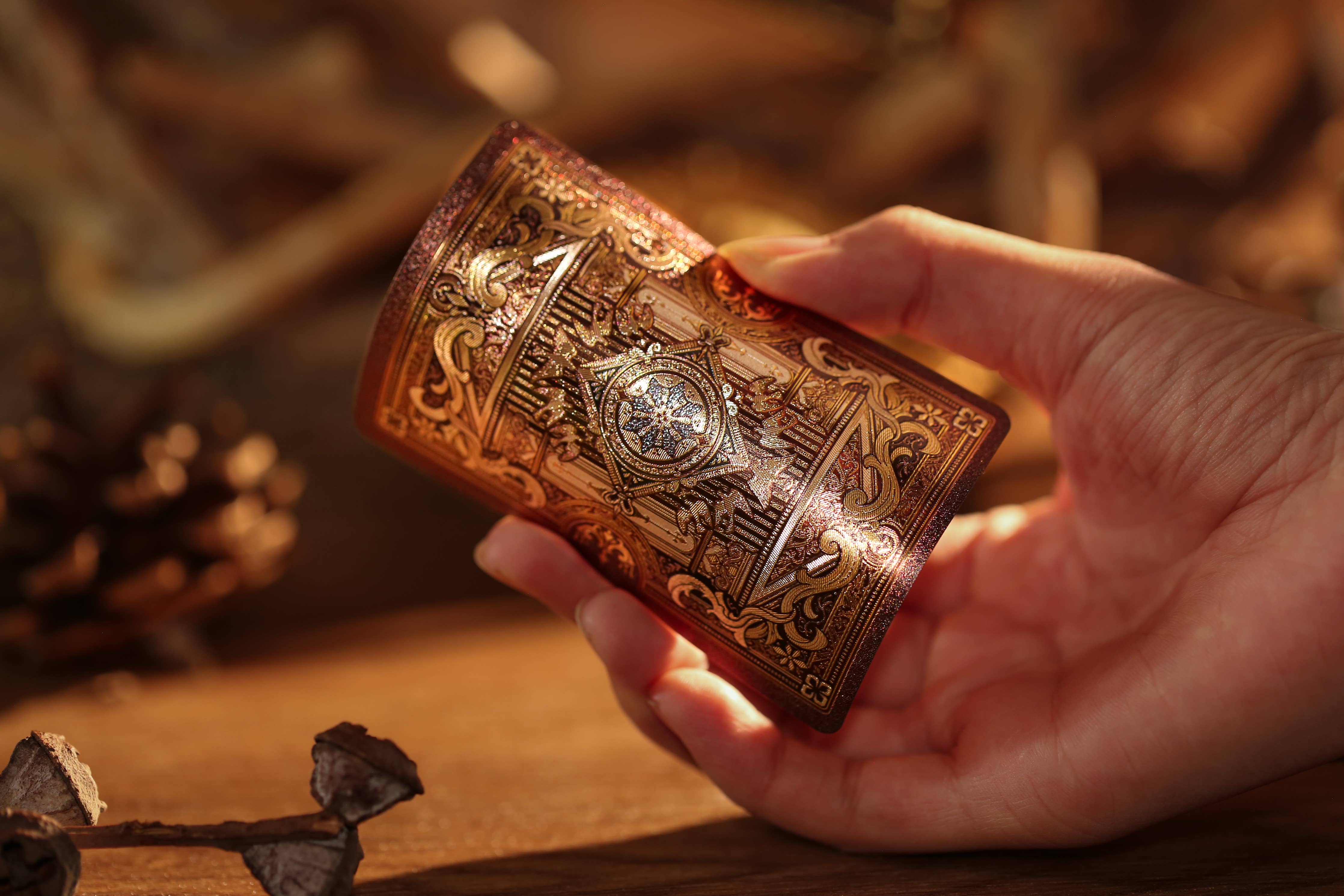 Hand holding a intricately designed wooden box with a blurred natural background
