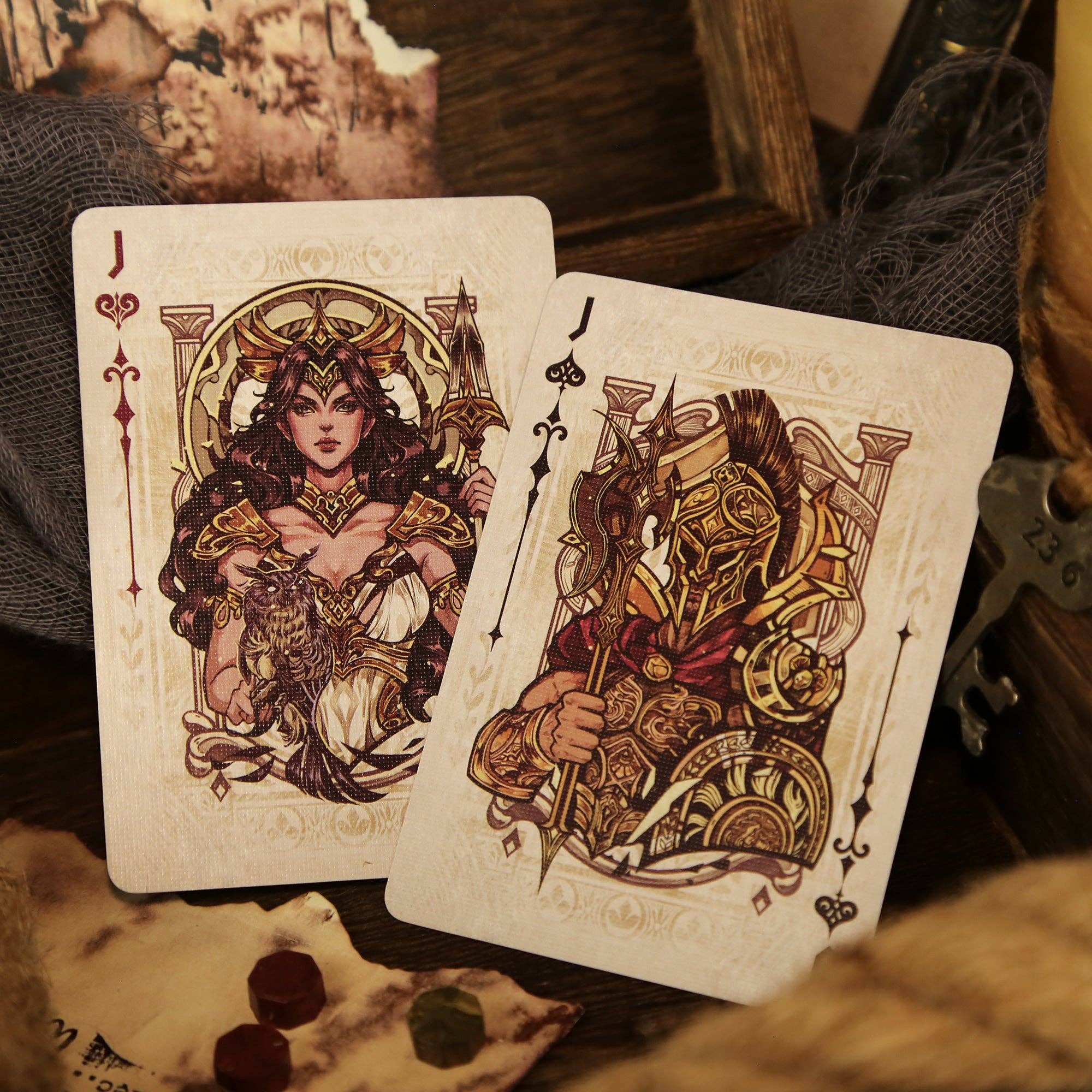 Two playing cards featuring intricate designs of a woman and a man on a textured surface.