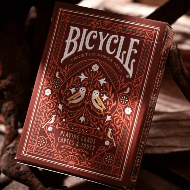 Close-up of Bicycle Aviary Orange tuck box showing metallic orange foil and ornate bird-and-floral design