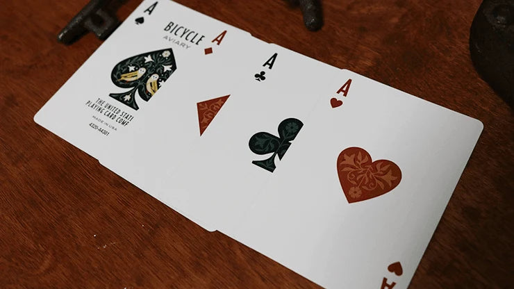 Four custom Aces from Bicycle Aviary Orange with illustrated suit symbols and ornate Ace of Spades