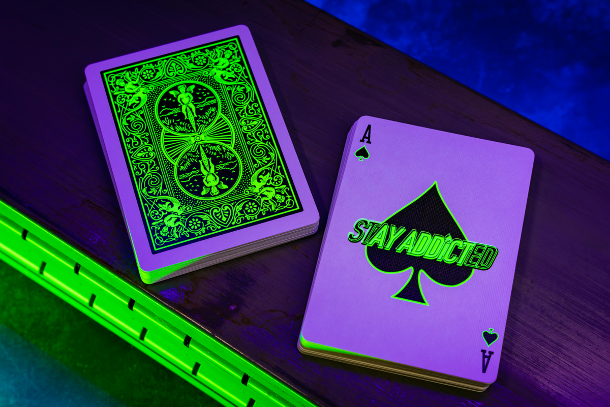 Bicycle Neon Green-Glo card back and Stay Addicted Ace of Spades under UV blacklight