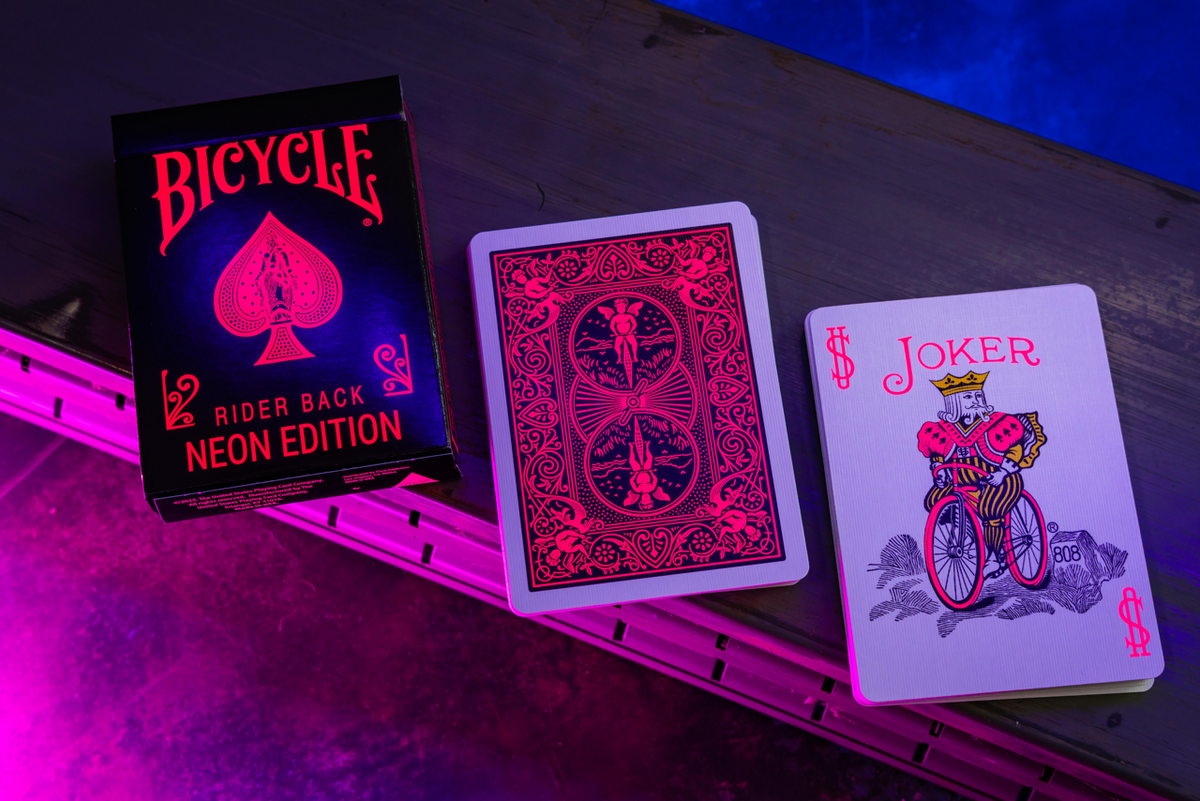 Bicycle Neon Star-Fire Pink tuck box, pink card back, and custom Joker under UV blacklight