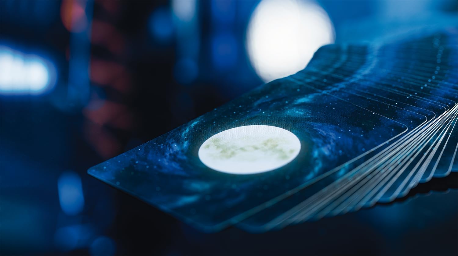 Bicycle Stargazer New Moon playing cards fanned to show the luminous moon and blue galaxy card backs