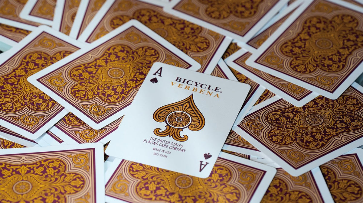 Bicycle Verbena Ace of Spades surrounded by burgundy and gold custom playing-card backs