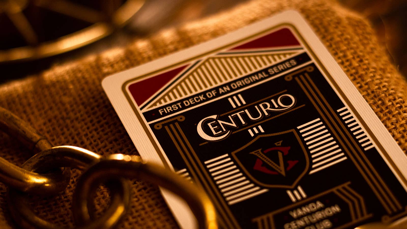 Playing card with 'Centurio' branding on a textured surface with gold accents