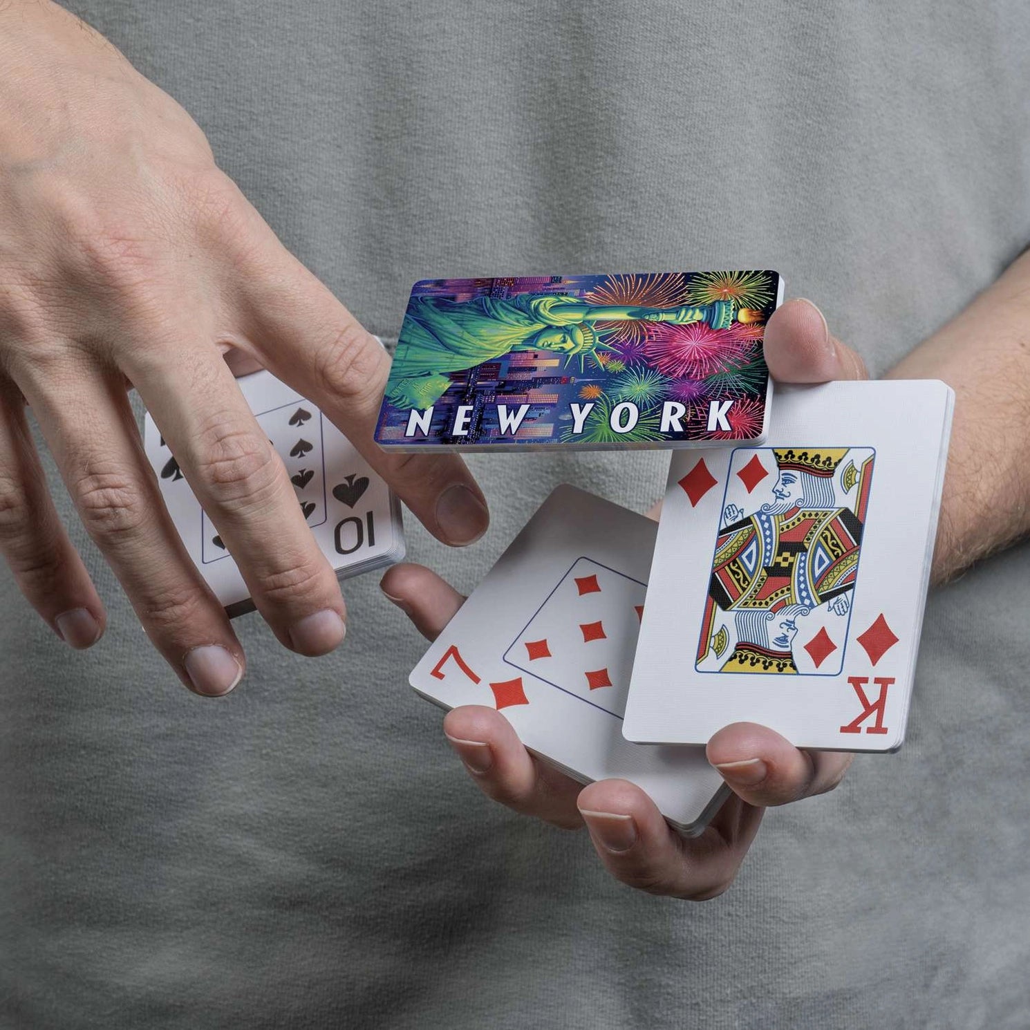 New York’s Lady Liberty card back displayed during a card flourish with traditional playing-card faces