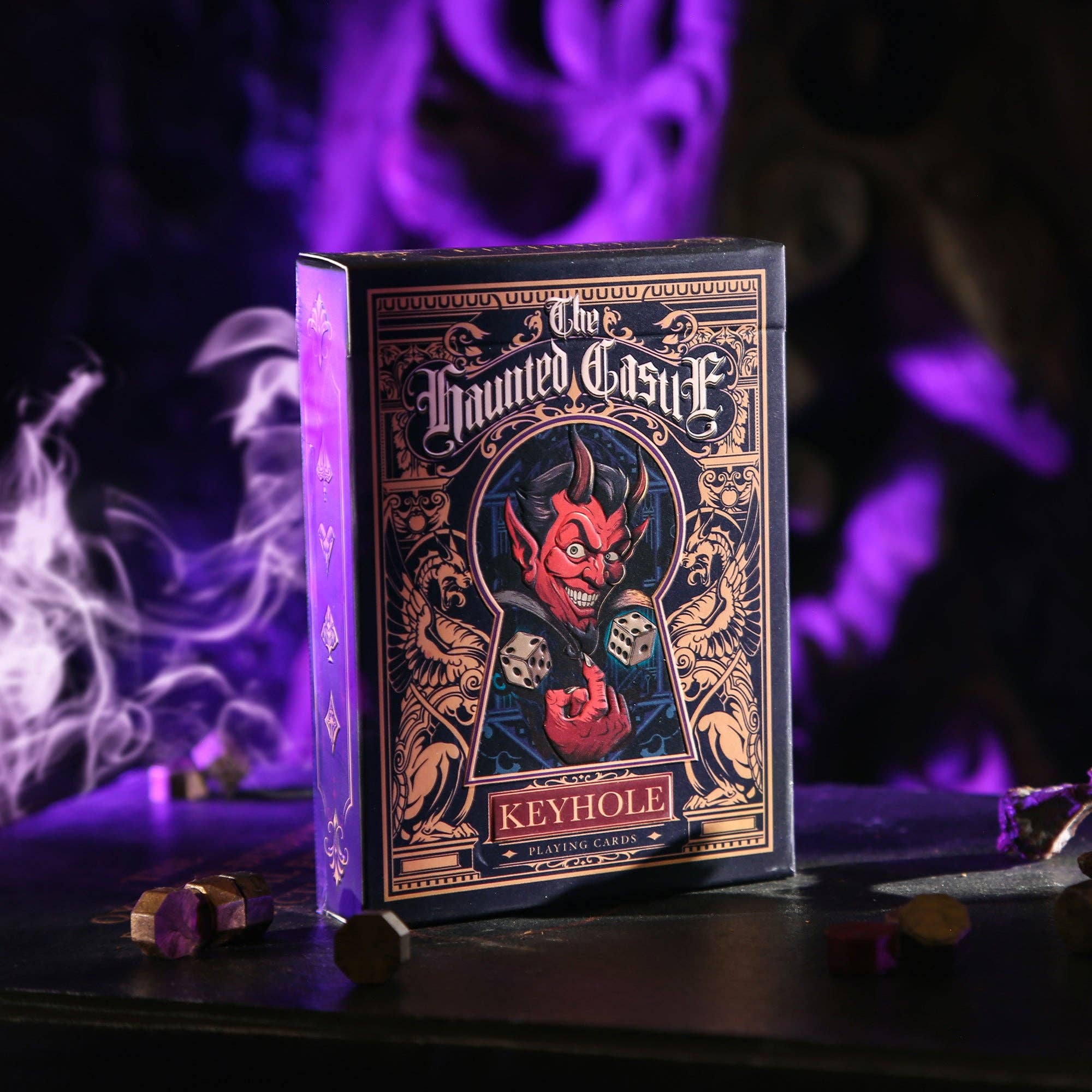 Playing card box with a devil design on a dark background with purple and white smoke effects.