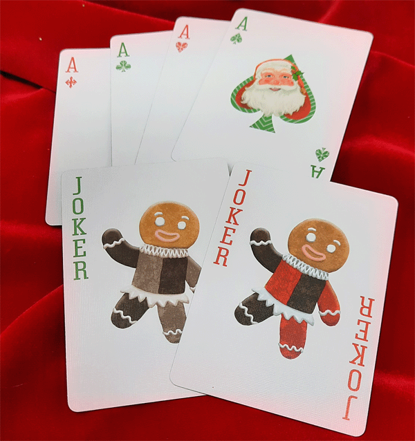 Playing cards with Christmas-themed designs on a red fabric background