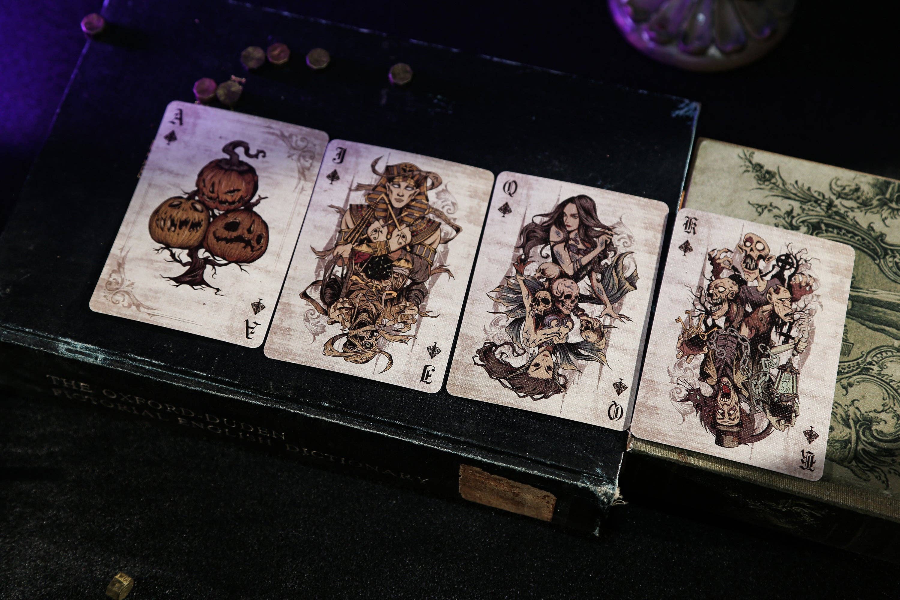 Set of playing cards with artistic designs on a dark surface