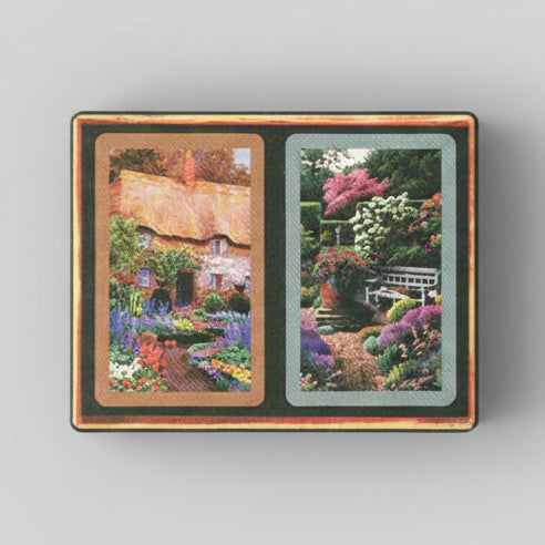 Cardboard Congress card decks with scenic illustrations of a thatched-roof cottage and a rose garden.