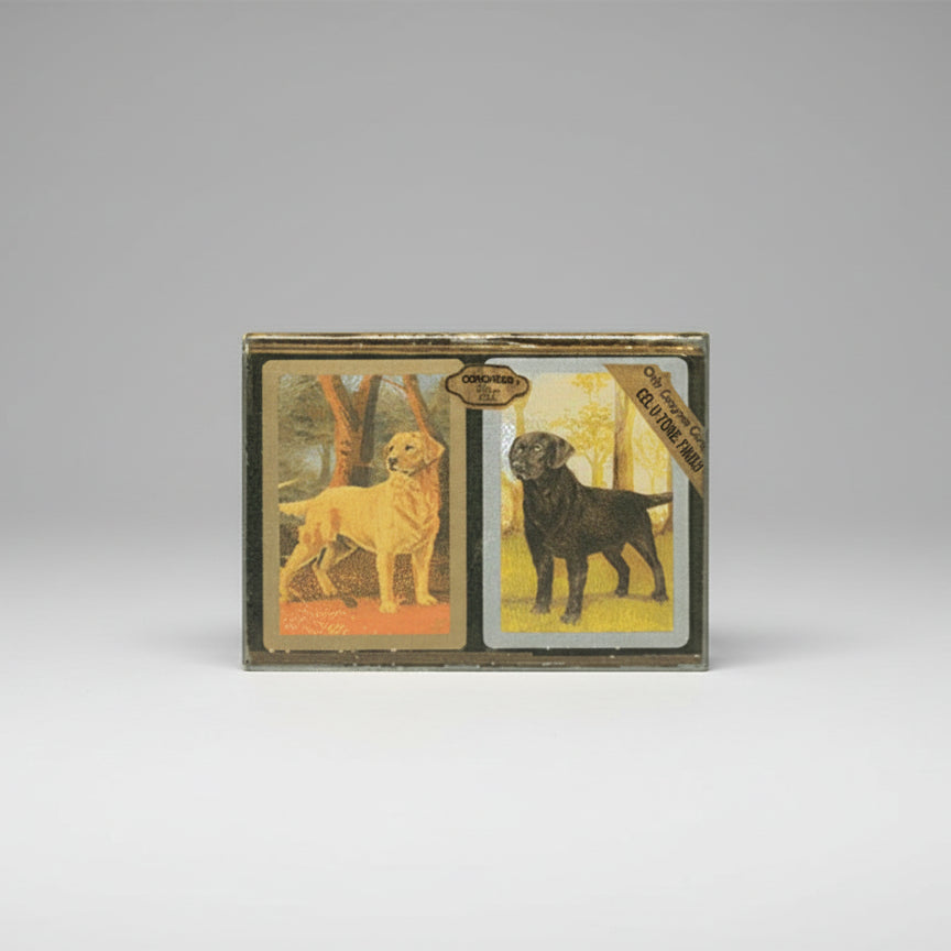 Two Congress dog playing cards with labels on a wooden surface