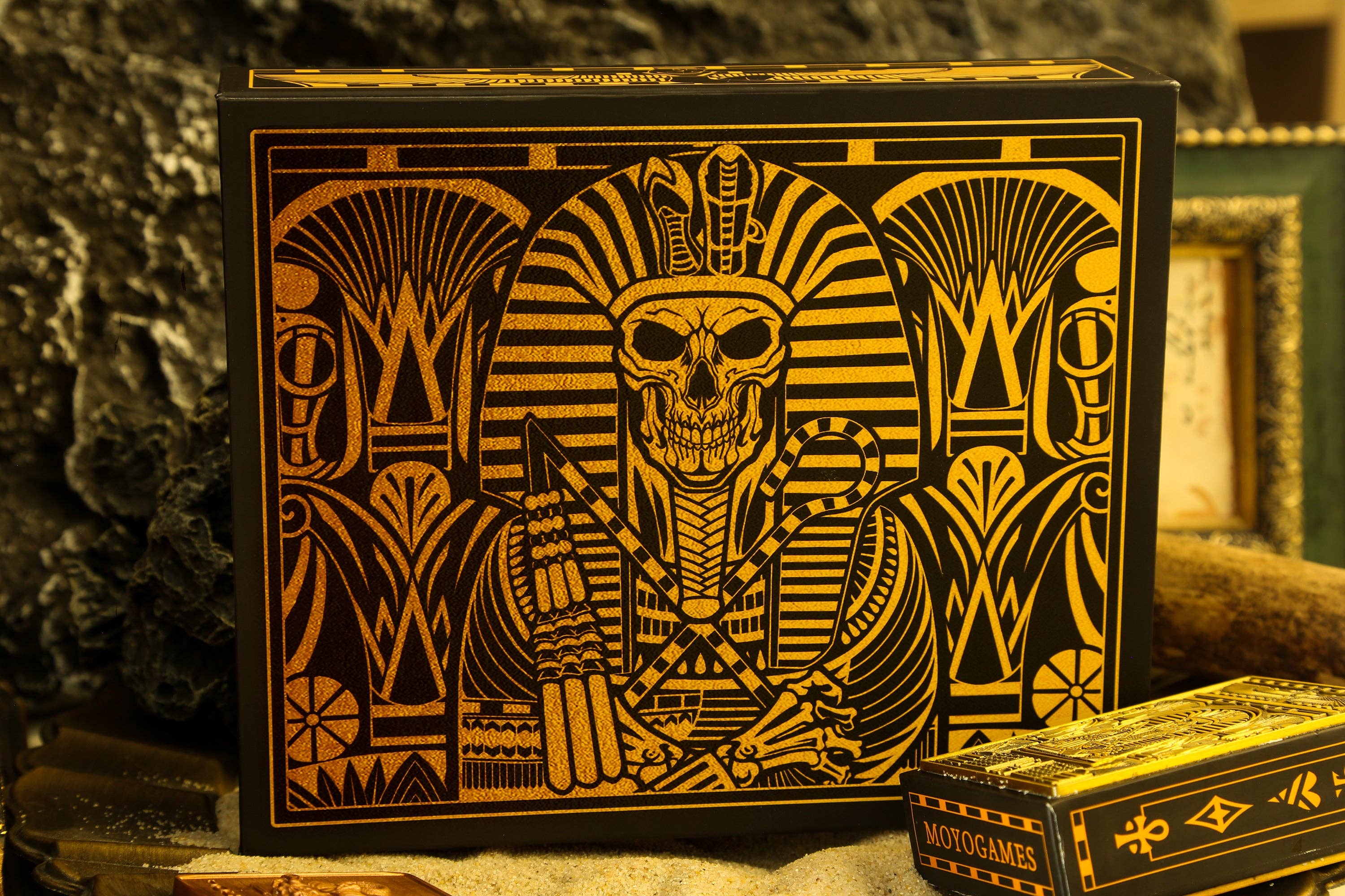 Decorative box with a skull in a Pharaoh's headdress design on a stone surface.
