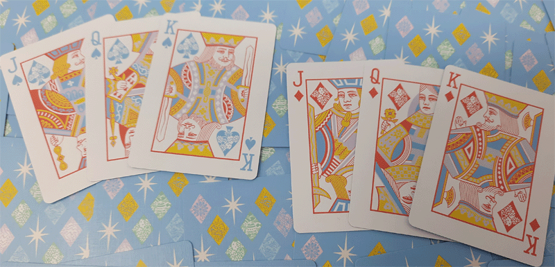 Playing cards including kings and jacks on a patterned blue background