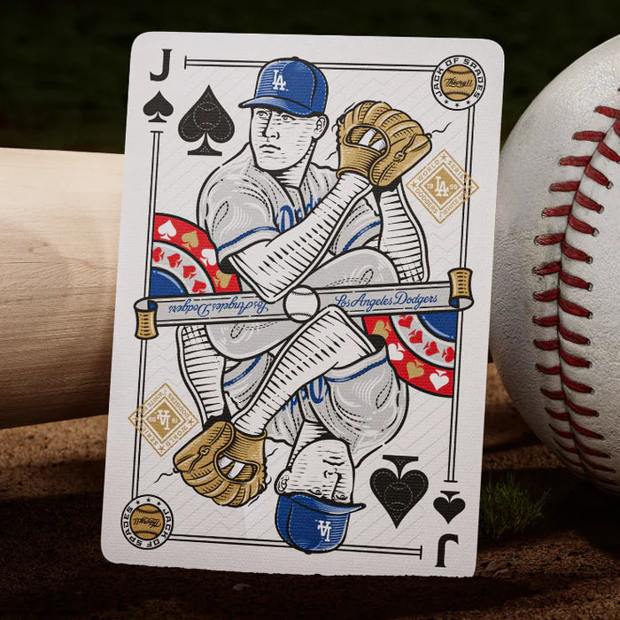 Jack of spades pitcher card from Dodgers deck resting on infield dirt beside a baseball.