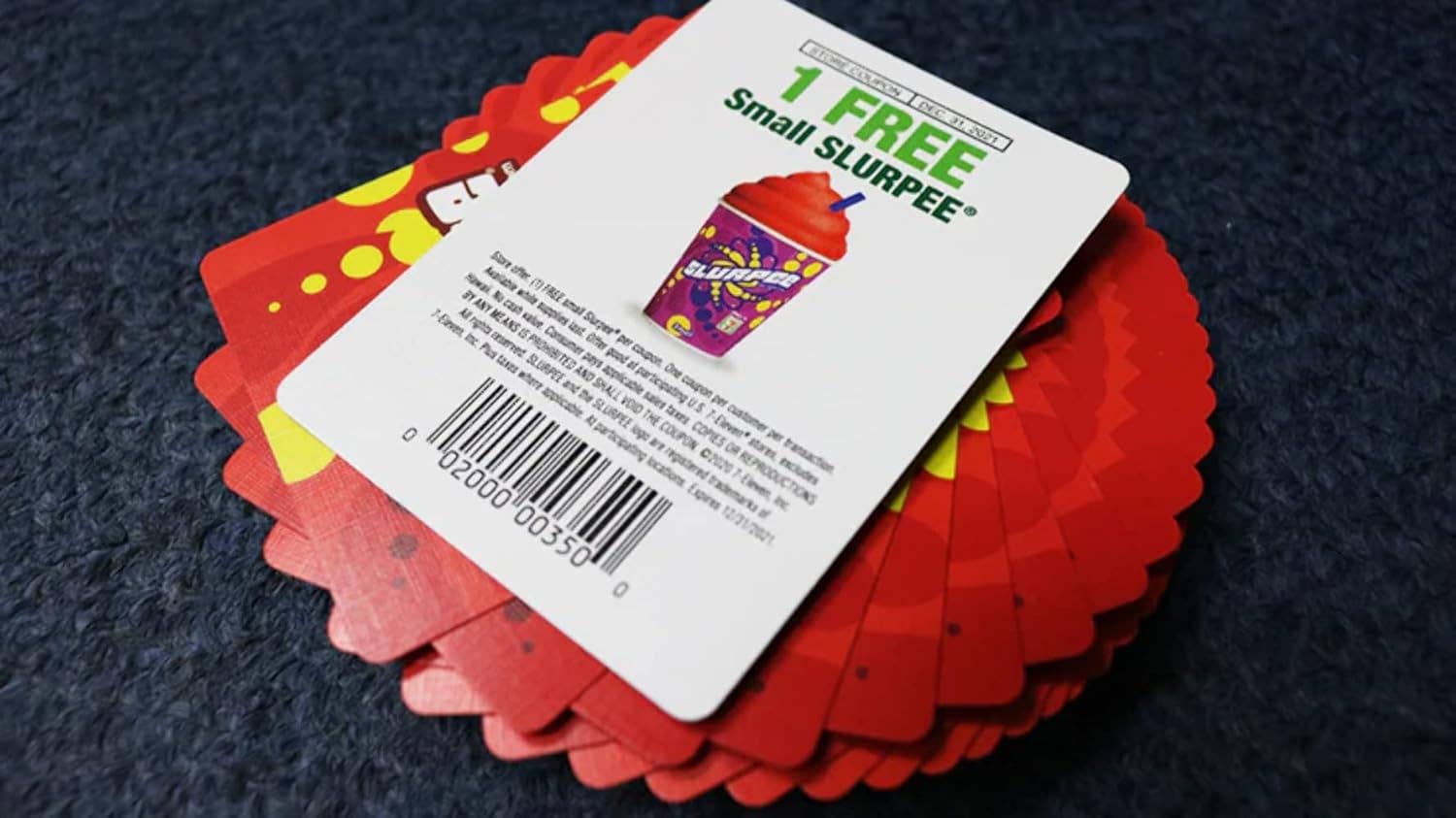 Red cards with a white slip featuring a Slurpee offer on a dark background