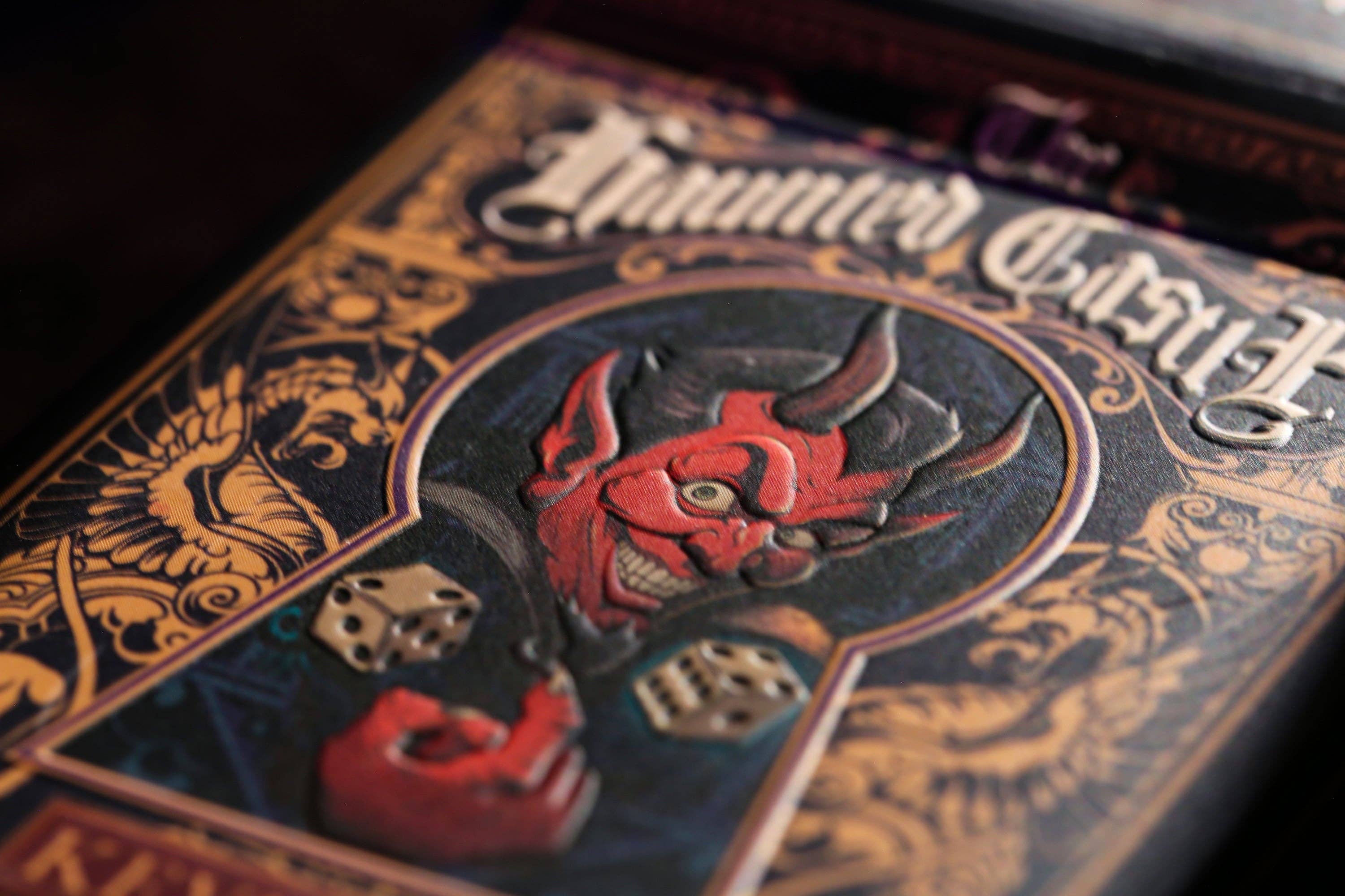 Decorative box cover with a red devil face and dice, titled 'The Haunted Castle'.