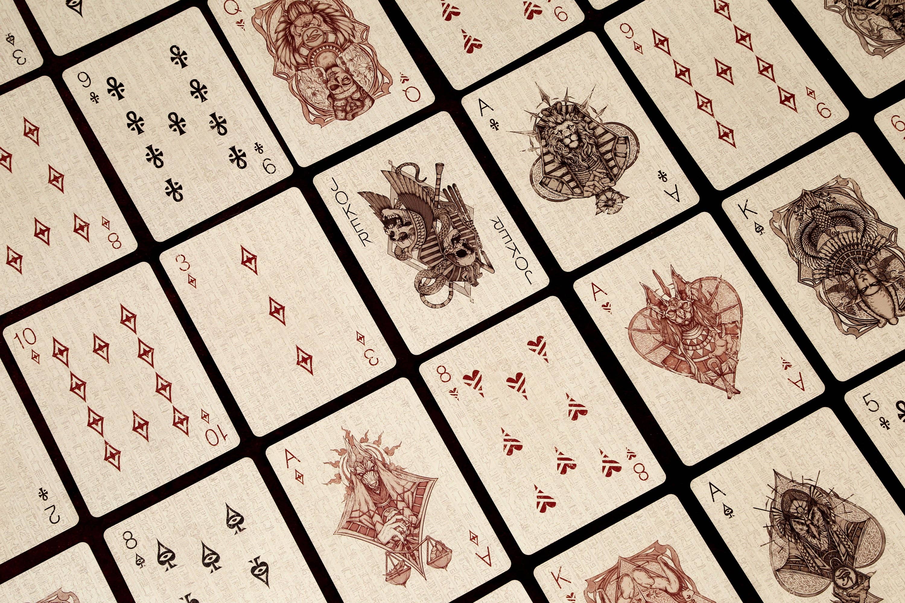 Close-up of vintage playing cards with intricate designs on a beige background