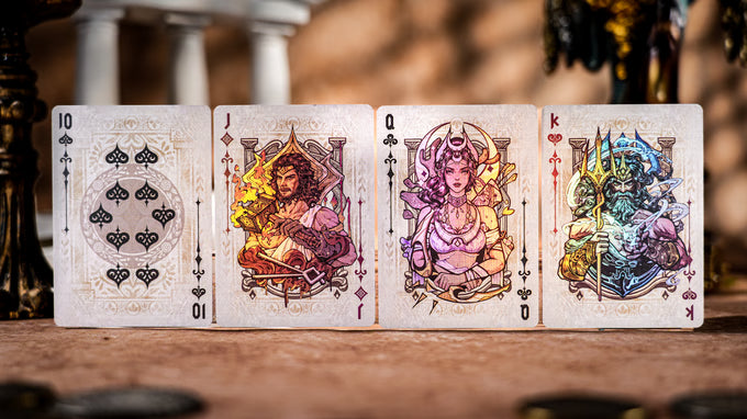 Four Keyhole Luxury Edition playing cards with colorful designs on a wooden surface.