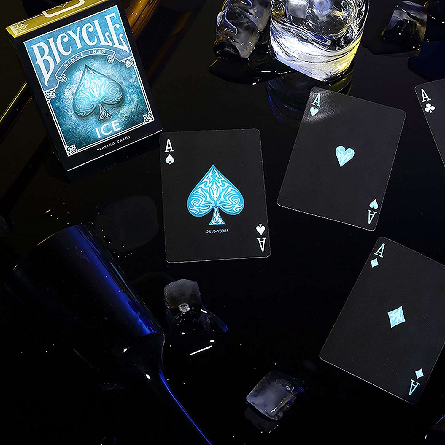 Bicycle Ice playing cards on a dark surface with ice cubes and a bottle.