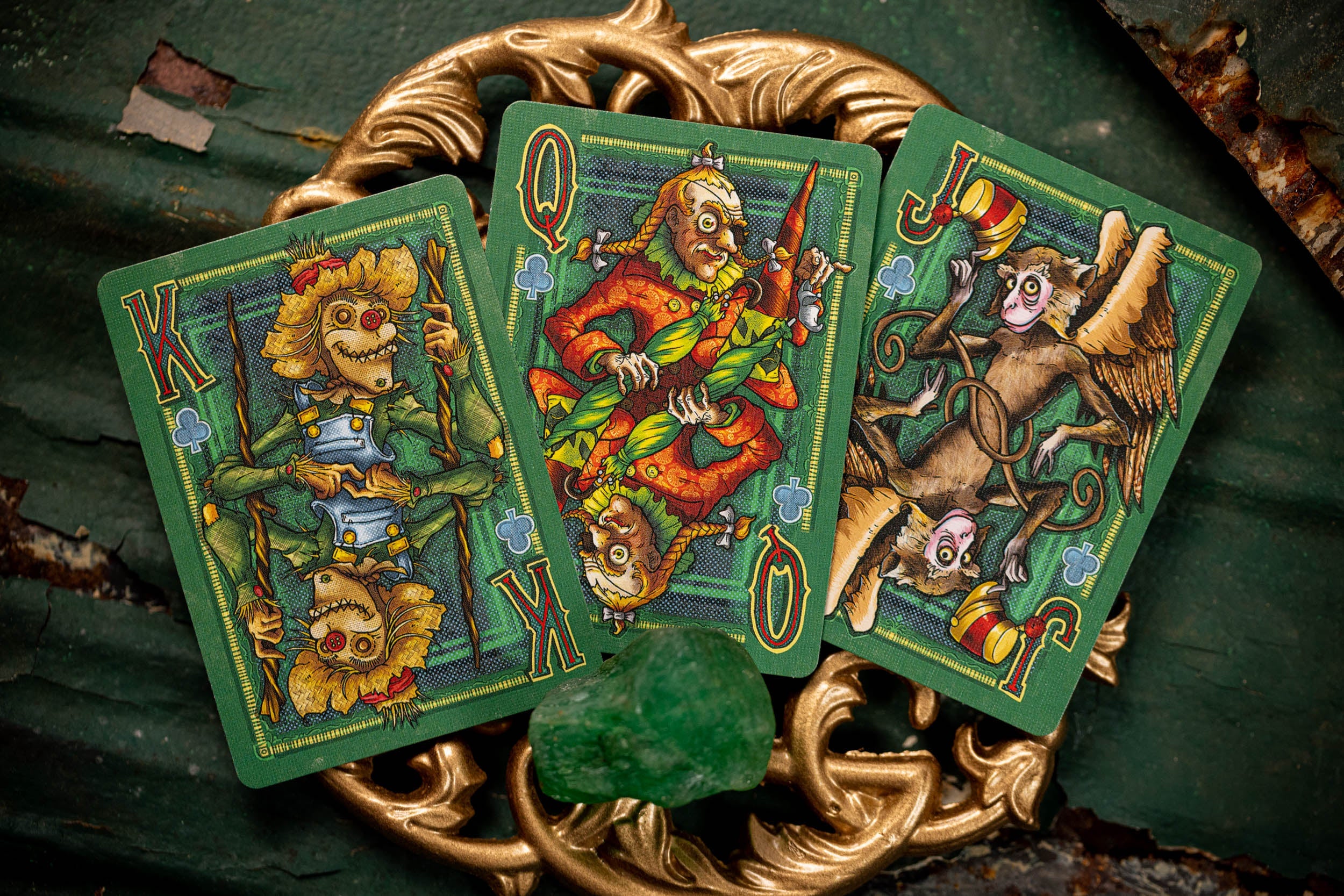 Three colorful playing cards with fantasy characters on a decorative stand.