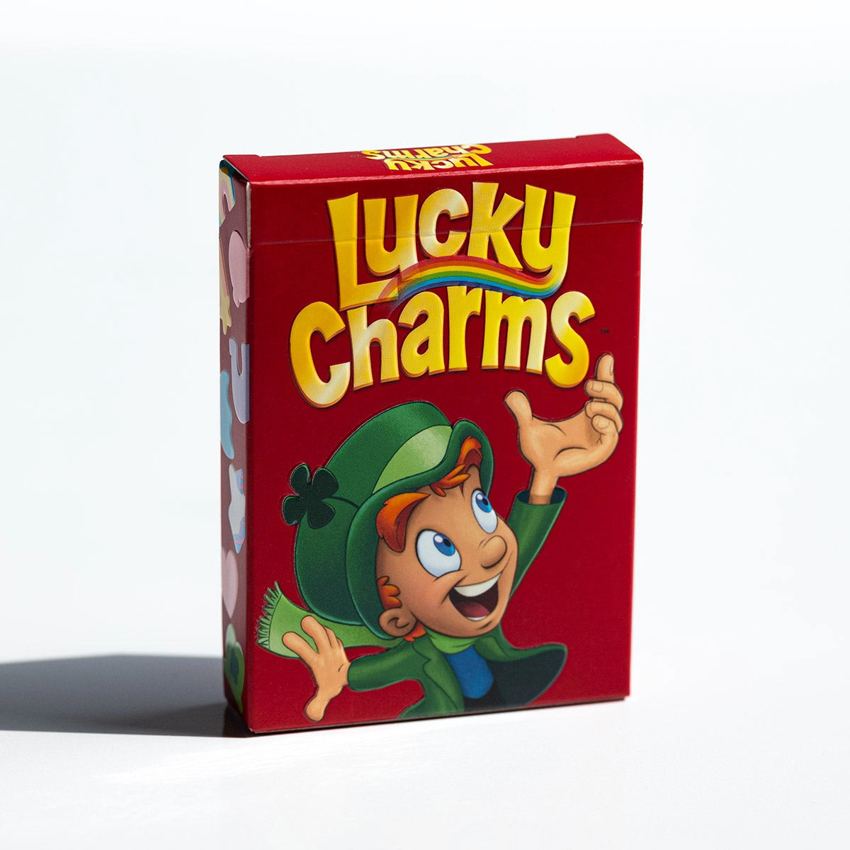 Front of the red Lucky Charms playing cards tuck box featuring Lucky the Leprechaun and yellow cereal lettering.