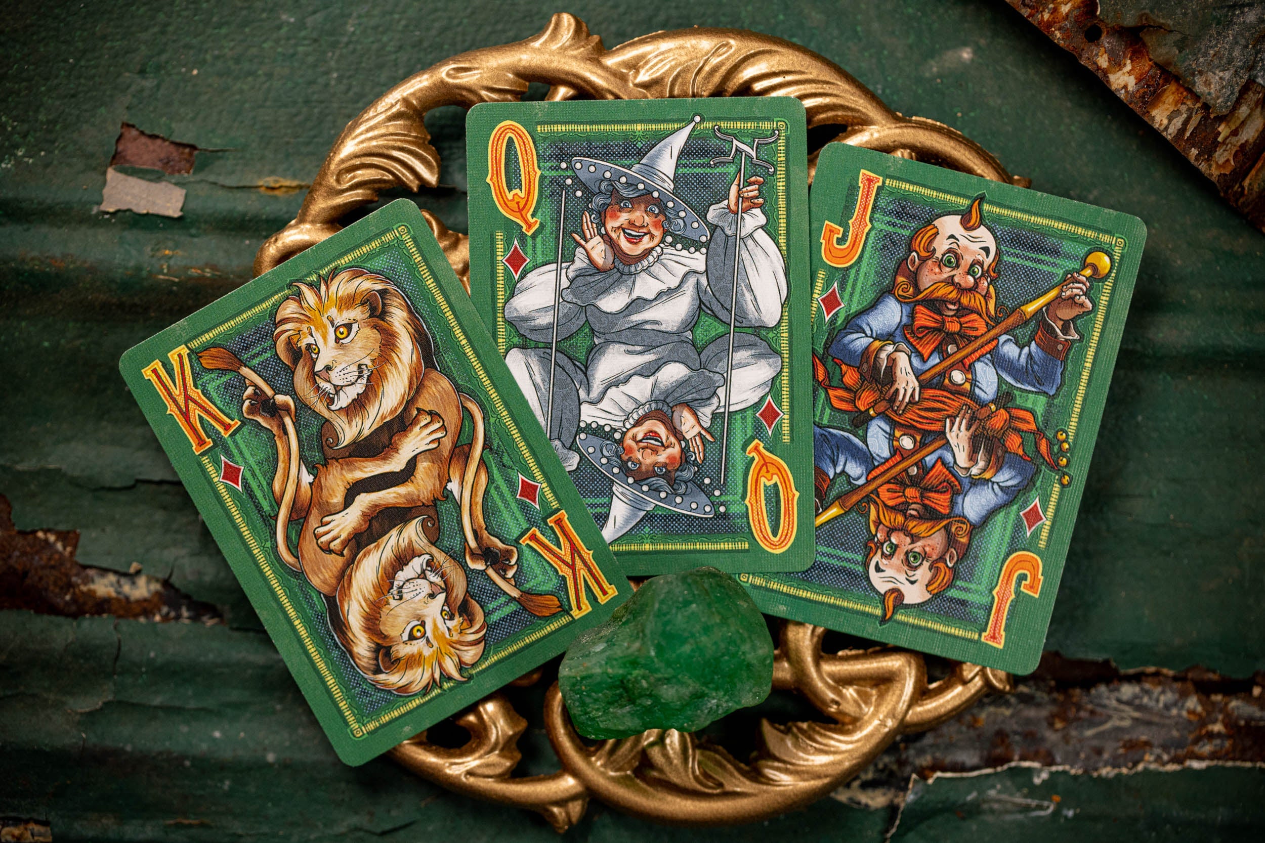 Three playing cards with colorful artwork on a textured surface