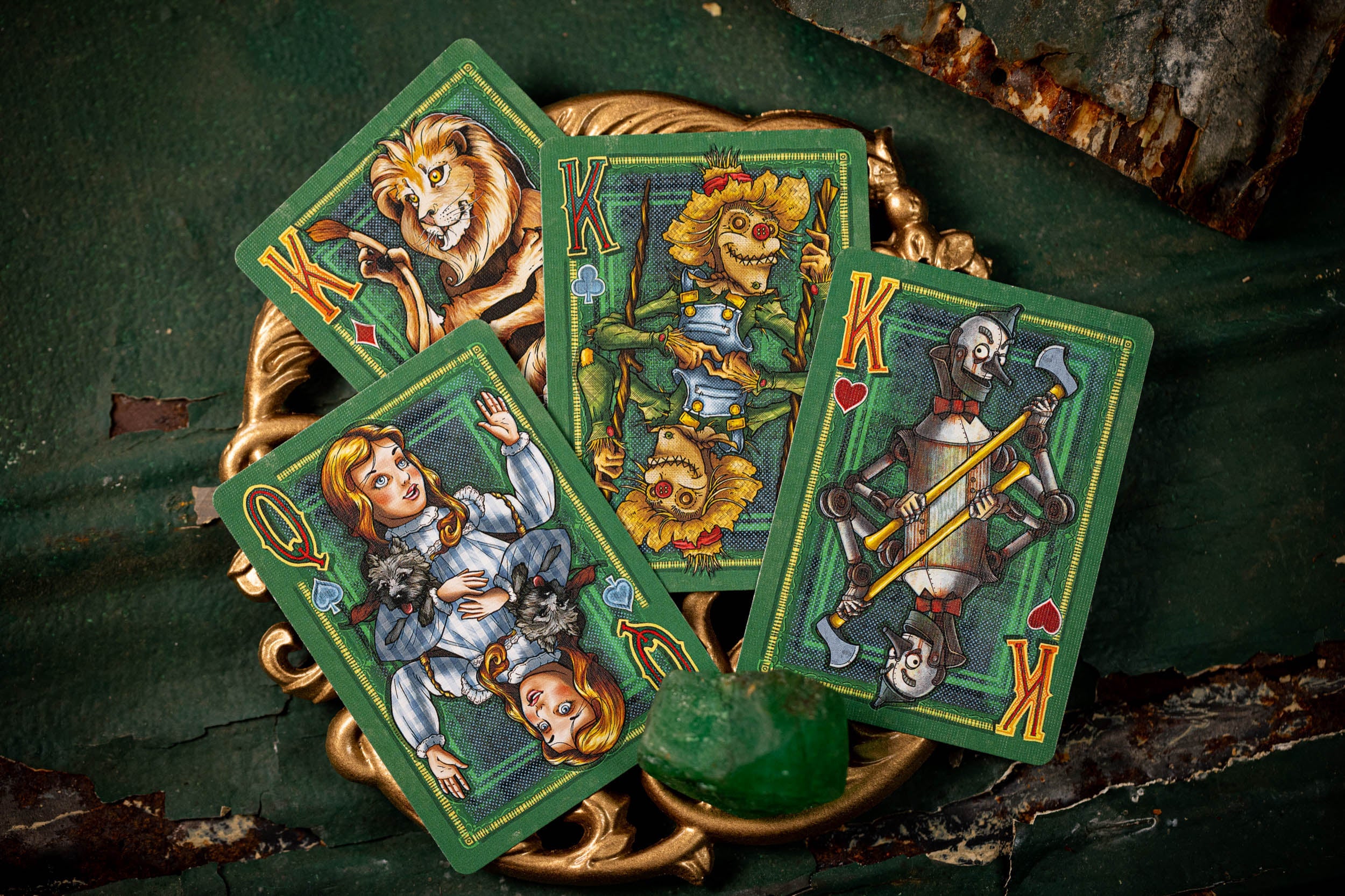 Four playing cards with colorful illustrations on a dark surface