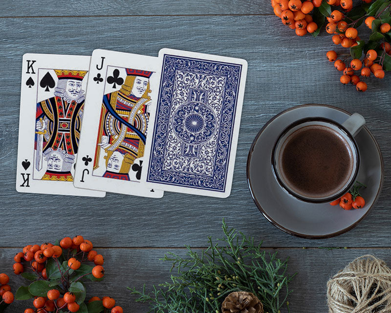 Piatnik 100% plastic bridge playing cards showing traditional court cards and blue back on a tabletop