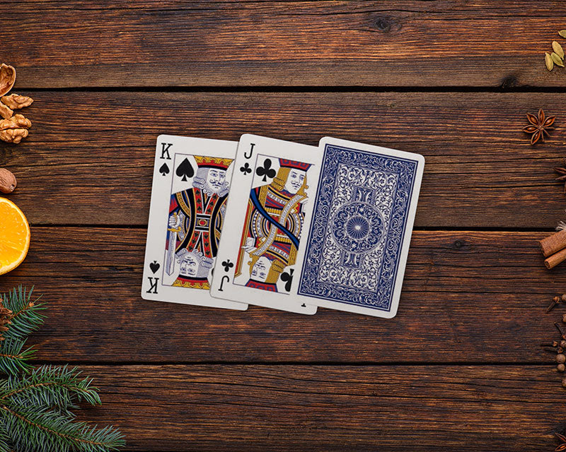 Piatnik 100% plastic bridge playing cards with blue back displayed on a wooden table