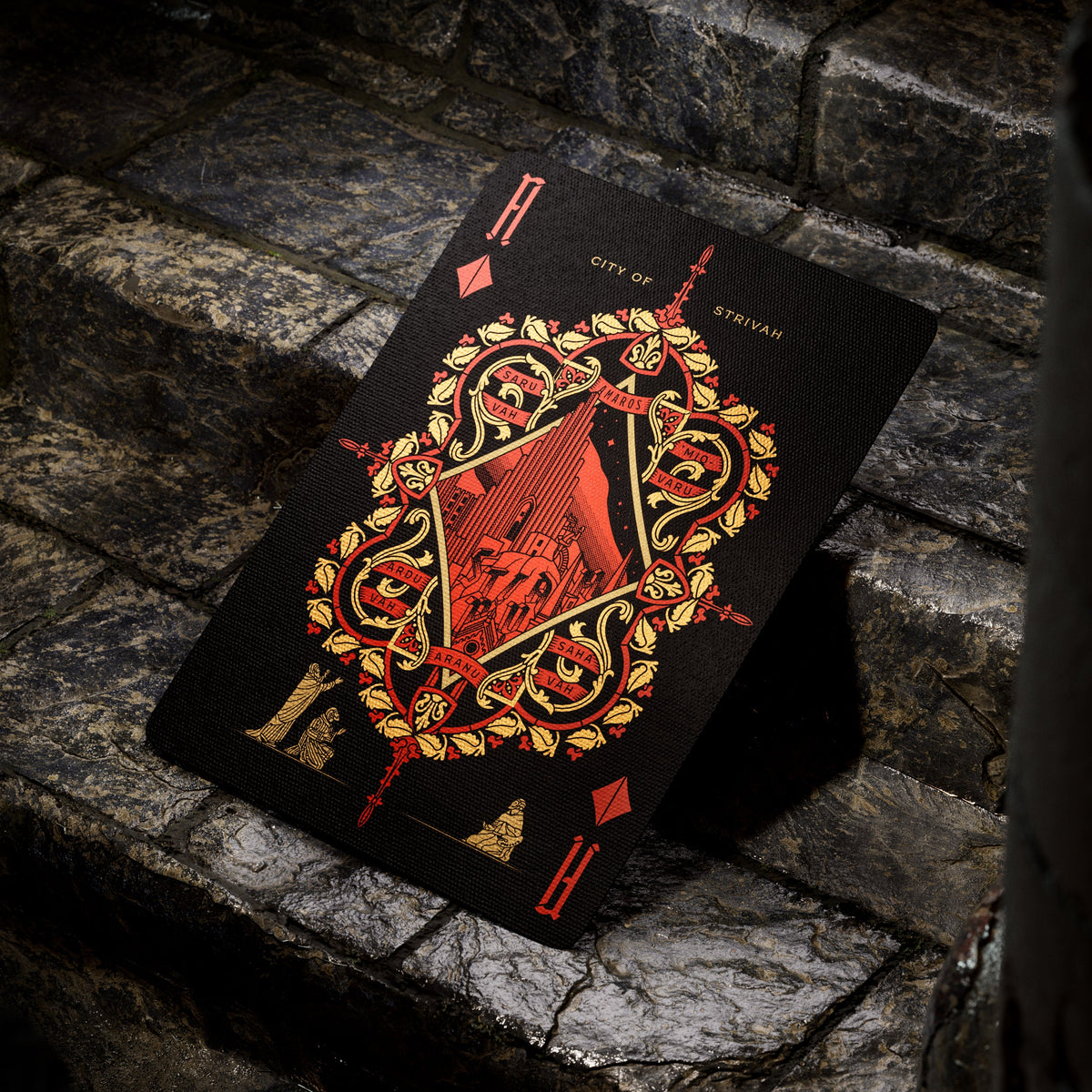 Theory11 Kovadrin Ace of Diamonds with a red city illustration inside a gold ornamental frame on a black card face.